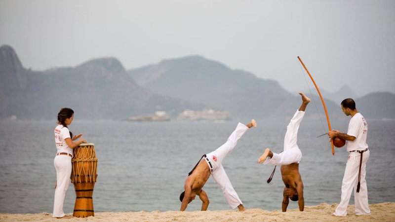 Capoeiristas praticando capoeira na praia do Flamengo - In Pictures Ltd./Corbis via Getty Images