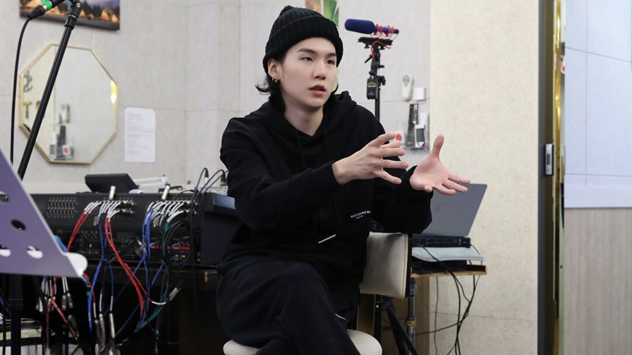 Suga, do BTS, surge em fotos dando aula de guitarra para crianças autistas