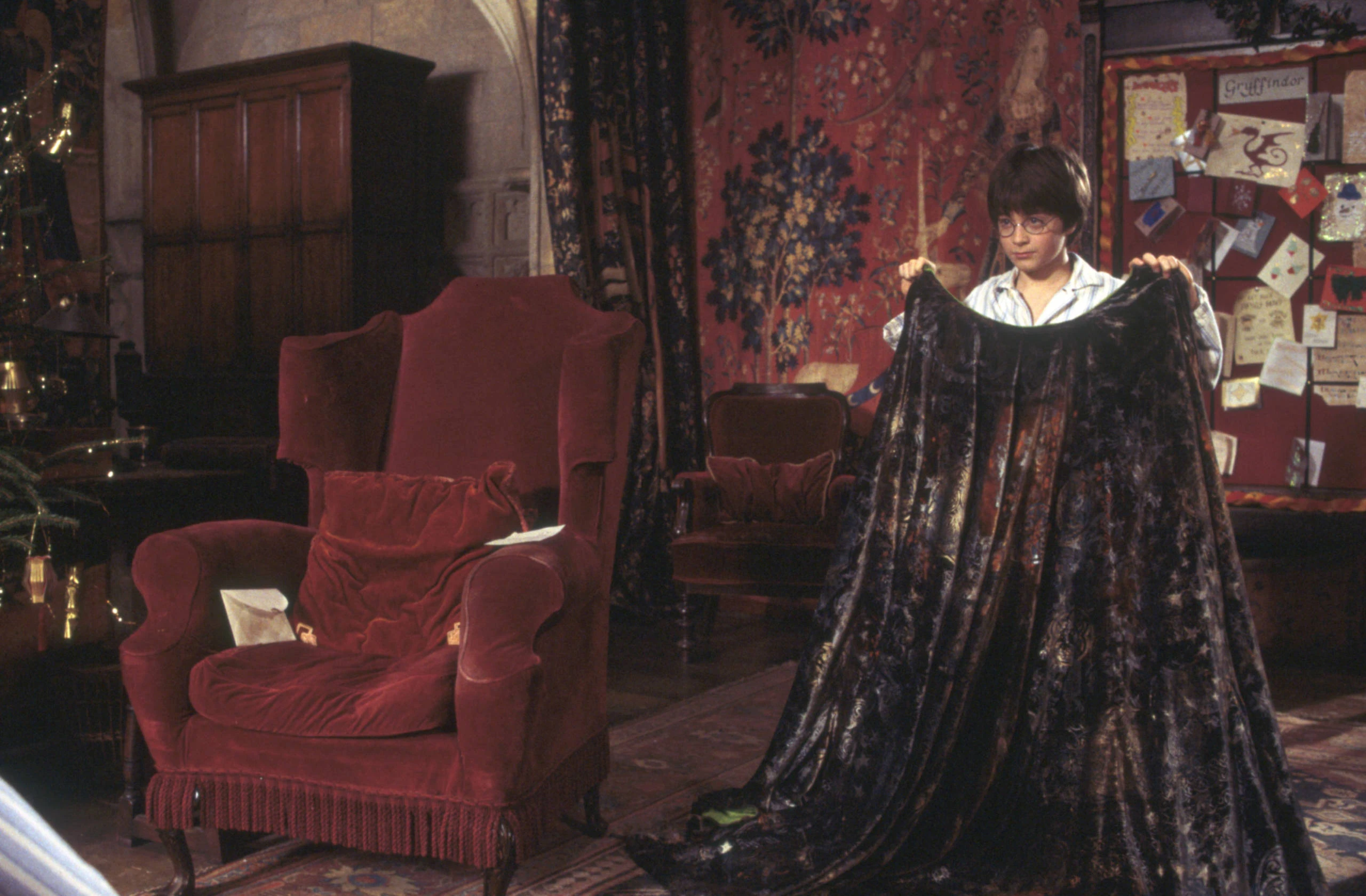 Harry Potter segurando a capa de invisibilidade