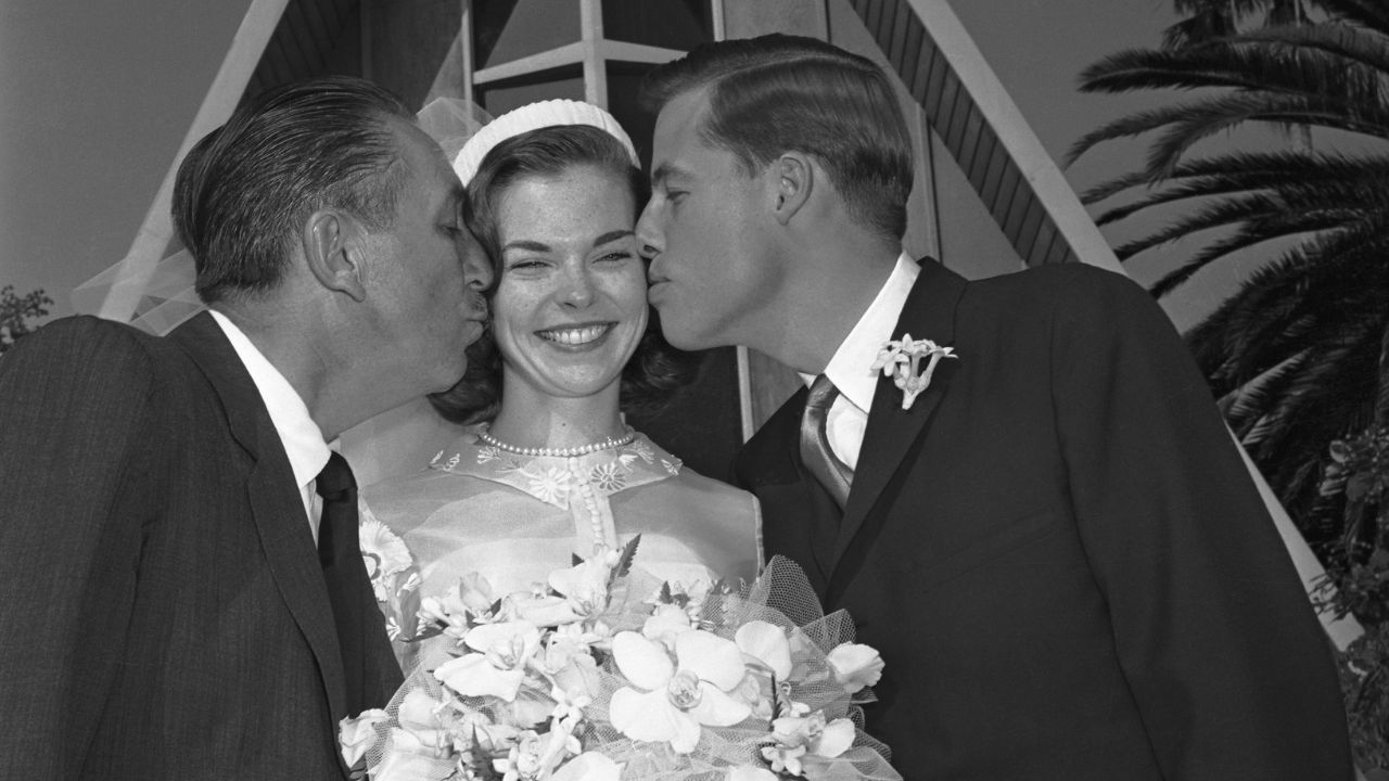 Sharon Mae Disney no dia de seu casamento com seu pai, Walt Disney (à esq.), e marido, Robert Brown (à dir.) - Getty Images