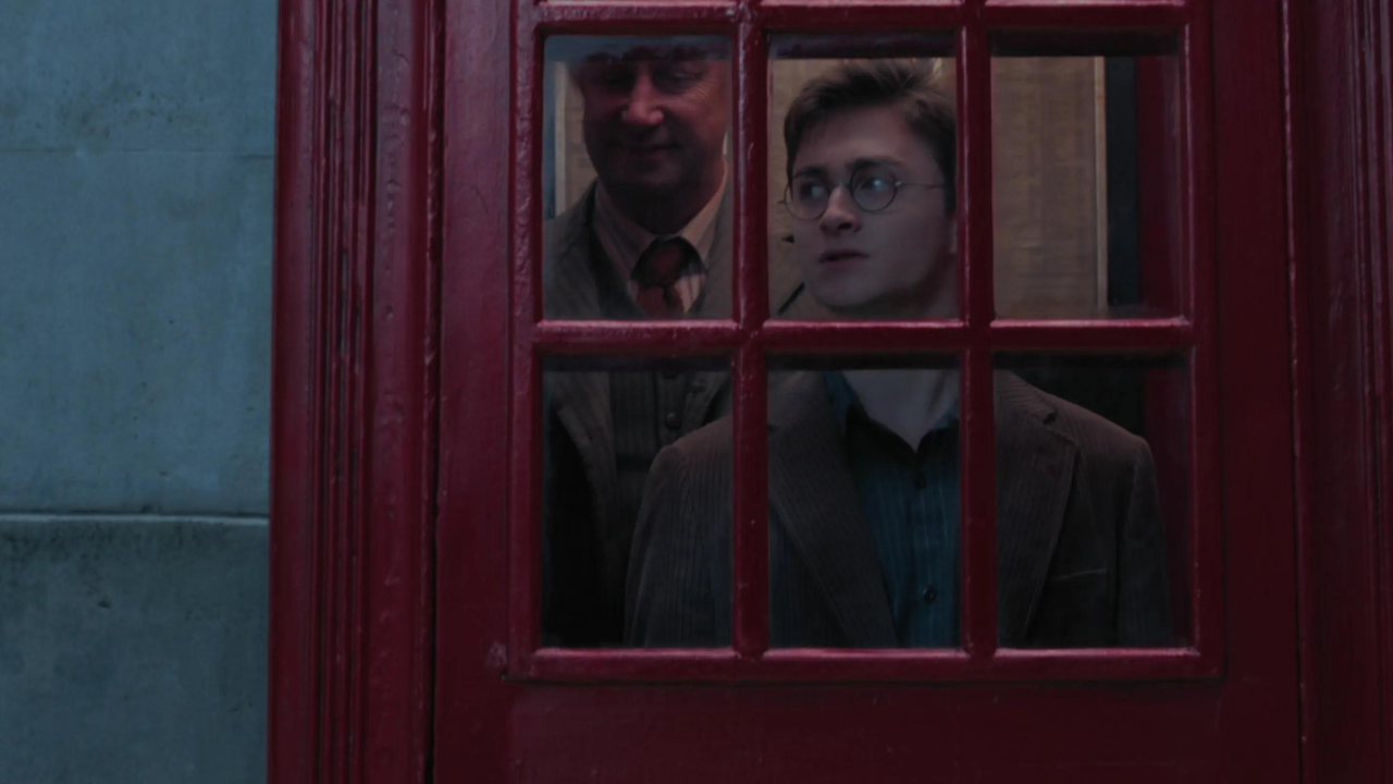 Harry Potter e Arthur Weasley usando uma cabine telefônica para entrar no Ministério da Magia